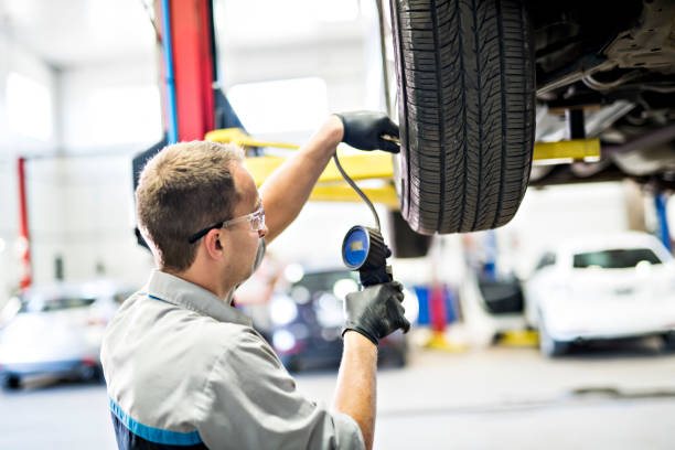 istock Handsome mechanic job in uniform working on car 1074278702