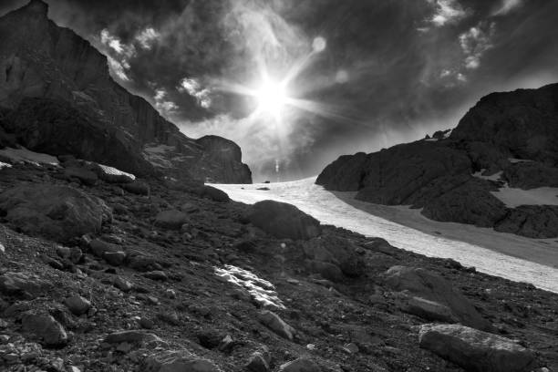 istock Mountain pass in snow and sky with sun and sunbeams 1074278762