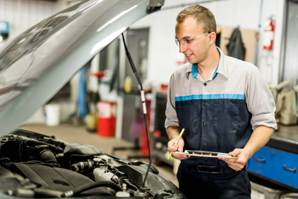 istock Handsome mechanic job in uniform working on car 1074278828