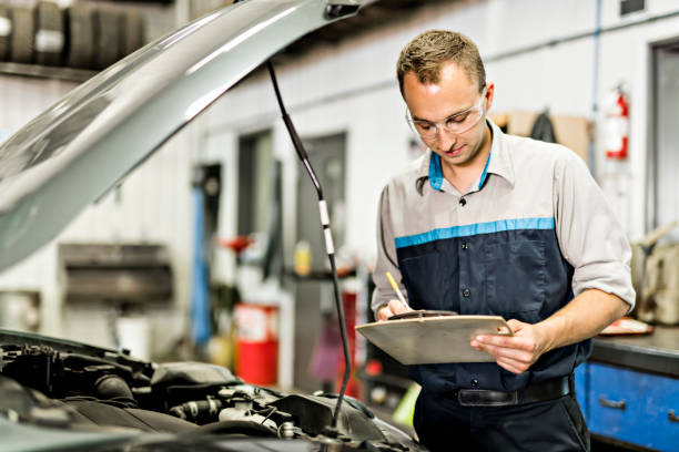 istock Handsome mechanic job in uniform working on car 1074278904