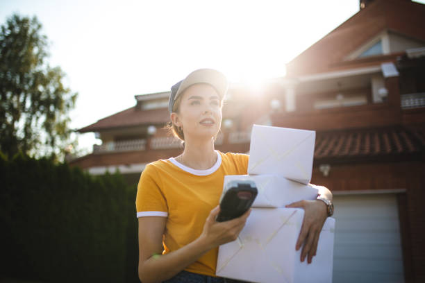istock Smiling postal worker girl delivering packages 1074281580