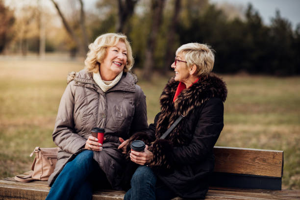 istock Women drinking coffee in the park 1074283210