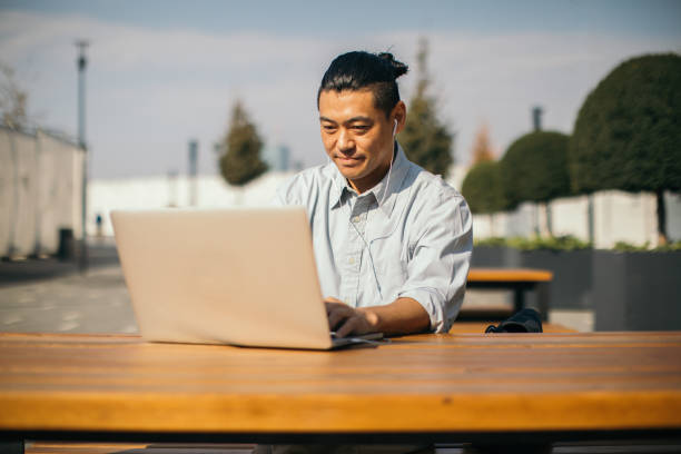 istock Mid adult Japanese is working on laptop 1074284056