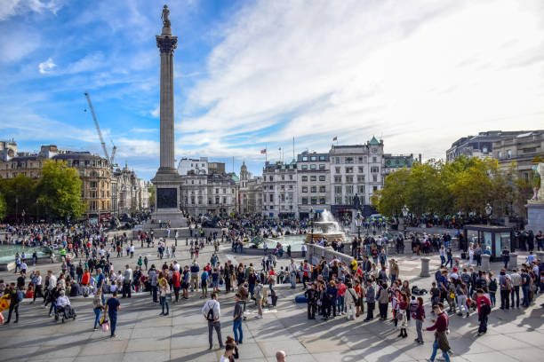 gente del posto e turisti che visitano e frequentaro trafalgar square nella city of westminster, londra, inghilterra, regno unito - il monumento di nelson foto e immagini stock