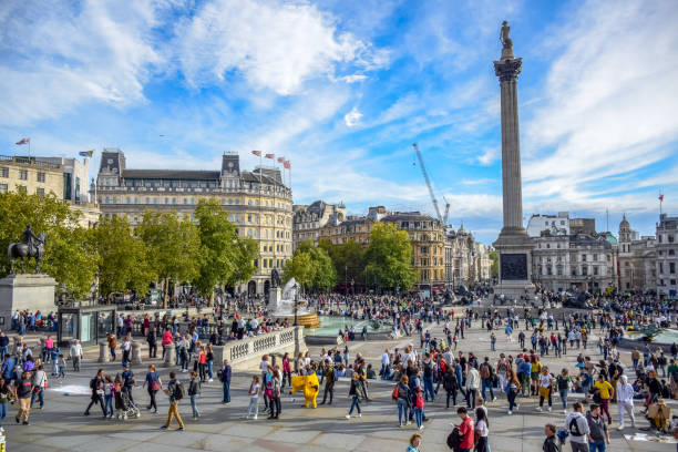 gente del posto e turisti che visitano e frequentaro trafalgar square nella city of westminster, londra, inghilterra, regno unito - il monumento di nelson foto e immagini stock