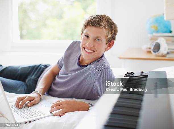 10 代の少年花輪のベッドでノートパソコンや電子機器 - ティーンエイジャーのストックフォトや画像を多数ご用意 - ティーンエイジャー, ピアノ, 少年