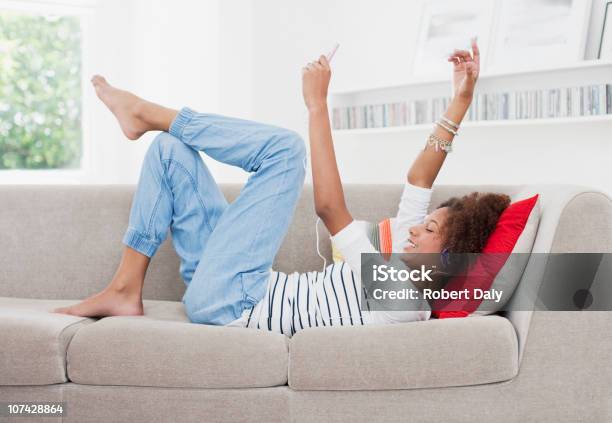 Adolescente Ragazza Ascoltando Il Lettore Mp3 - Fotografie stock e altre immagini di Divano - Divano, Piedi alzati, 14-15 anni