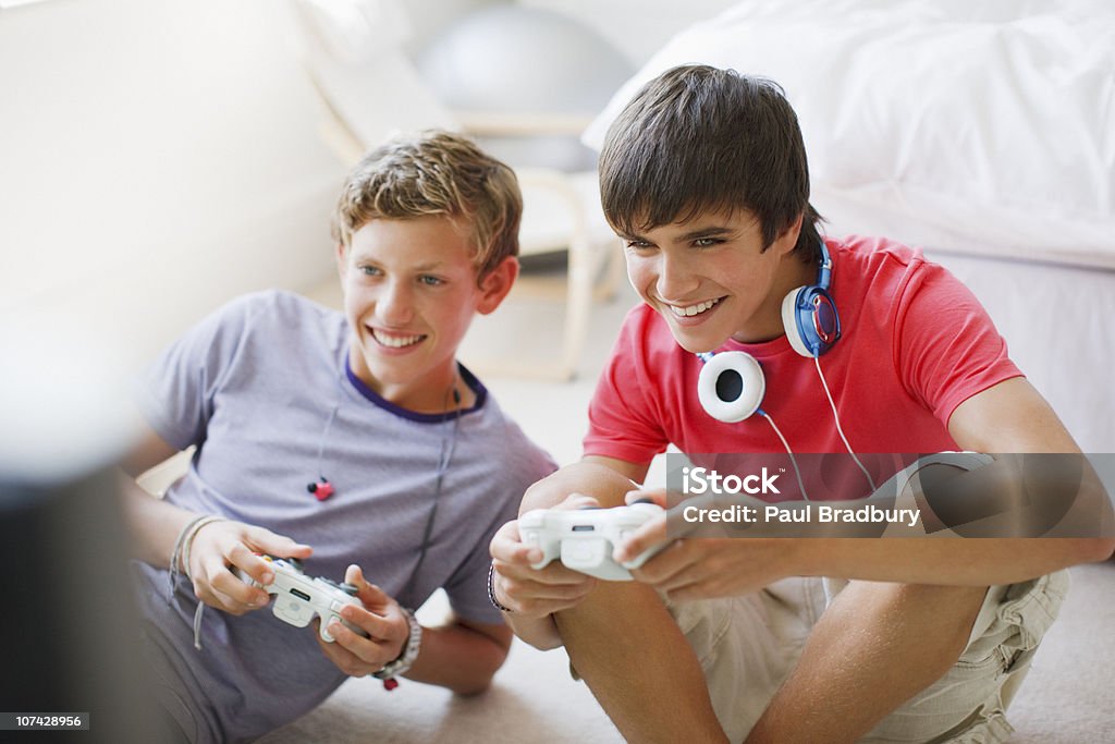 Sonriendo chicos adolescentes jugando videojuegos - Foto de stock de Videojuego libre de derechos