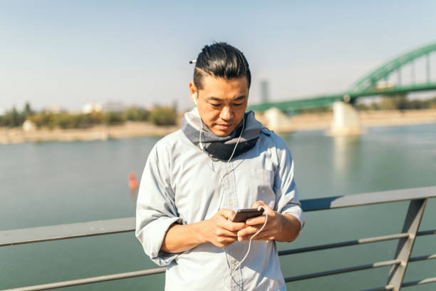 istock Mid adult Japanese using phone 1074289780