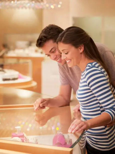 Photo of Smiling couple looking at jewelry case