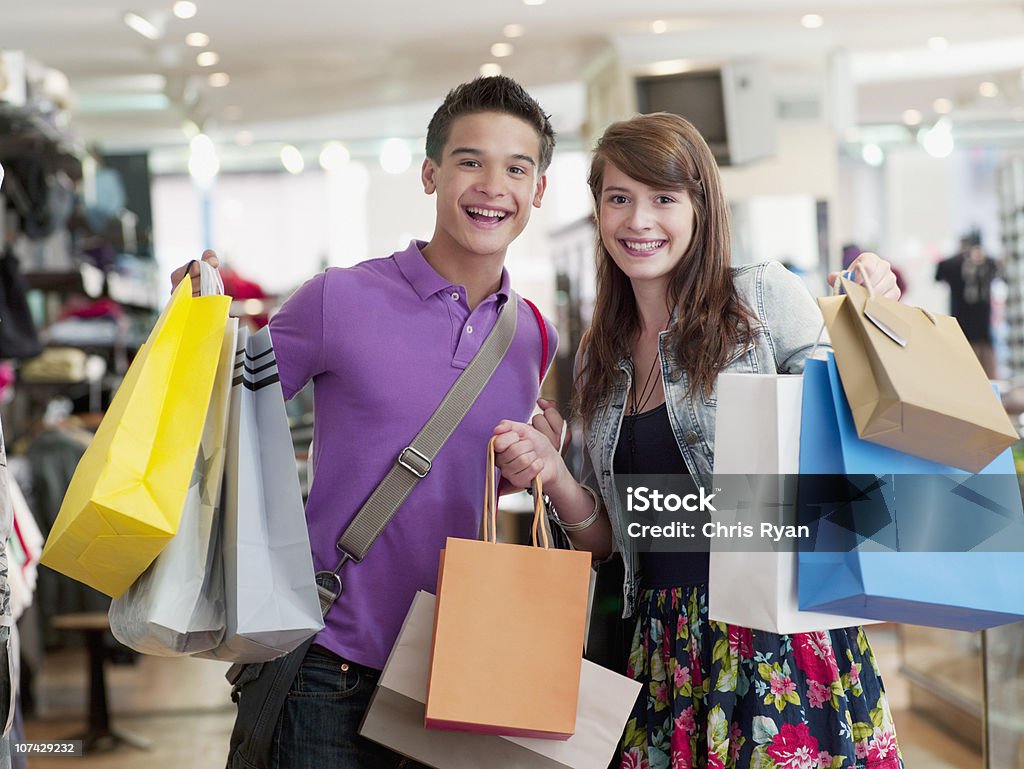 Casal sorridente Carregando sacos de compras na loja - Foto de stock de Comércio - Consumismo royalty-free