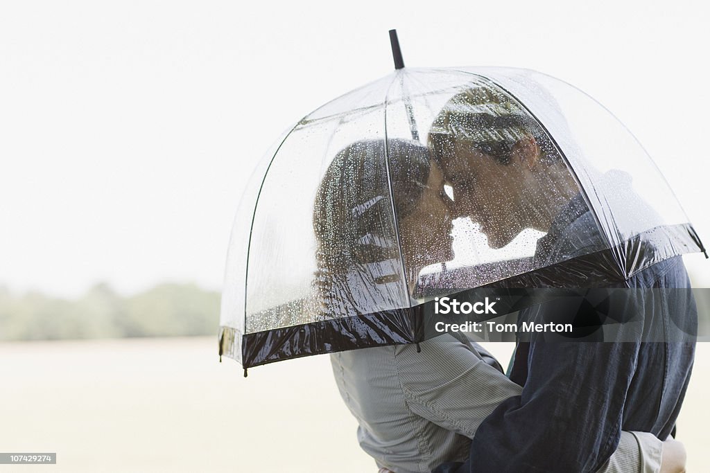 Casal abraçando sob guarda-chuva de chuva - Foto de stock de Guarda-chuva royalty-free