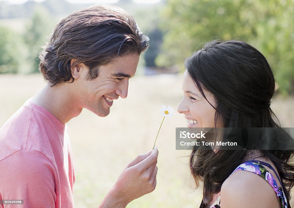 Homme souriant, donnant femme Marguerite - Photo de Marguerite libre de droits