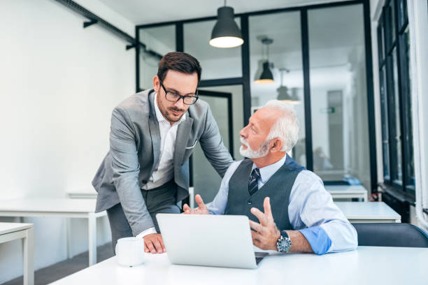 istock Young man discussing with boss or older employee in modern office. 1074293138