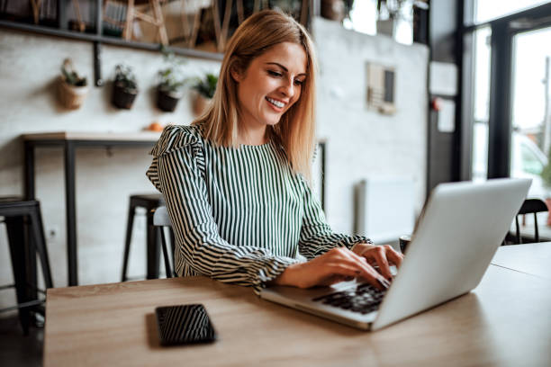istock Smiling woman typing on laptop indoors. 1074293350
