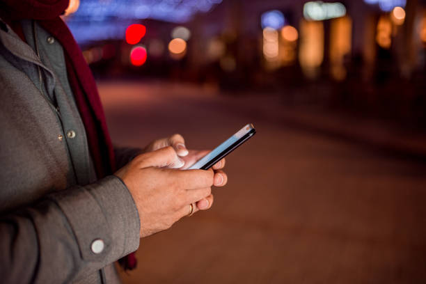 istock Male person using mobile phone outdoors at night. 1074293484