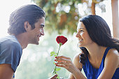 Smiling couple outdoors with red rose