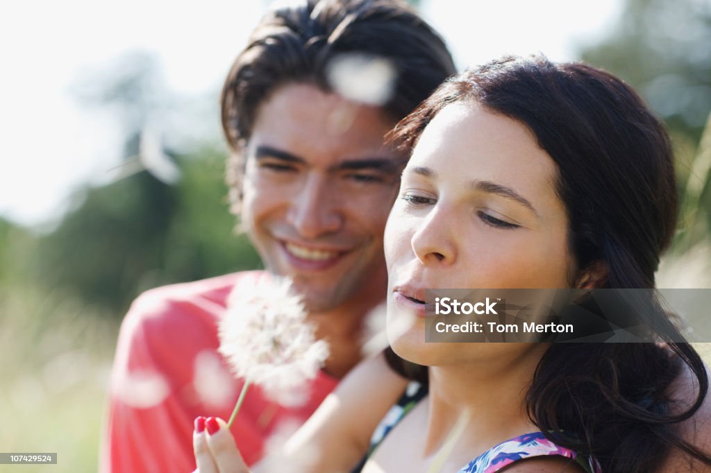 Casal, soprando sementes de Dente de Leão em - Foto de stock de Dente-de-Leão royalty-free