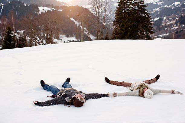 Couple making snow angels  snow angels stock pictures, royalty-free photos & images