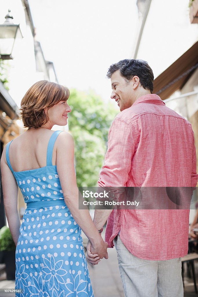 Sorrindo casal de mãos dadas e andando - Foto de stock de 25-30 Anos royalty-free