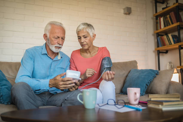 istock Senior couple at home checking blood pressure 1074296308