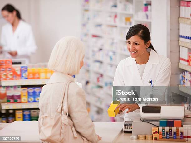 Farmacéutico Entregar Los Medicamentos En Farmacia Del Cliente Foto de stock y más banco de imágenes de Farmacia