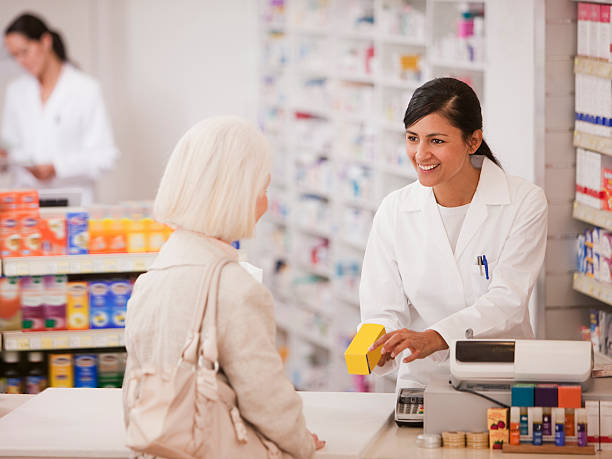 Pharmacist handing medication to customer in drug store  pharmacy tech stock pictures, royalty-free photos & images