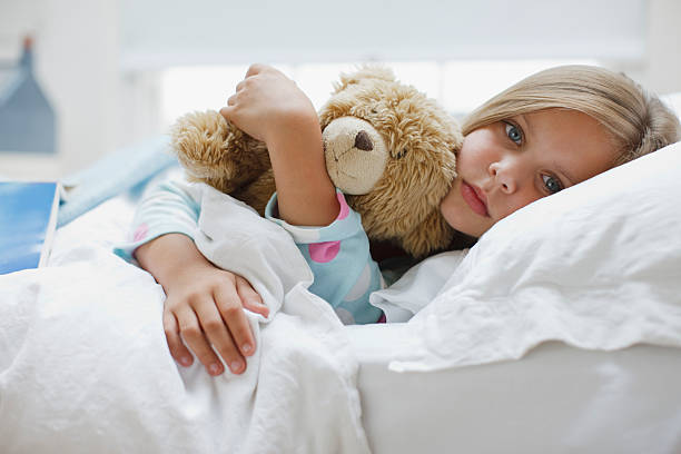 enjoado menina pôr na cama com urso de pelúcia - sick girl imagens e fotografias de stock