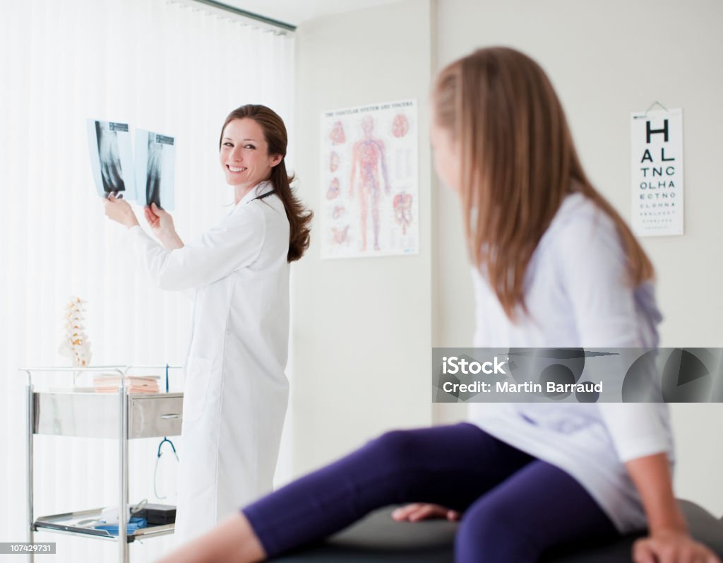 Doctor with young patient reviewing bone x-rays  X-ray Image Stock Photo