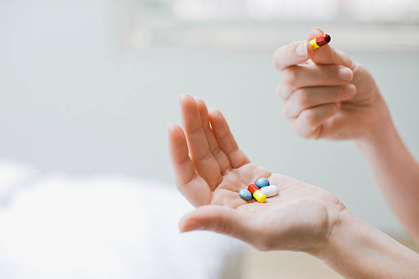 mujer tomando vitaminas y suplementos - pills fotografías e imágenes de stock