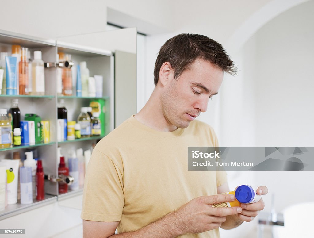 Hombre de instrucciones en recipiente para las píldoras - Foto de stock de Armario de aseo personal libre de derechos