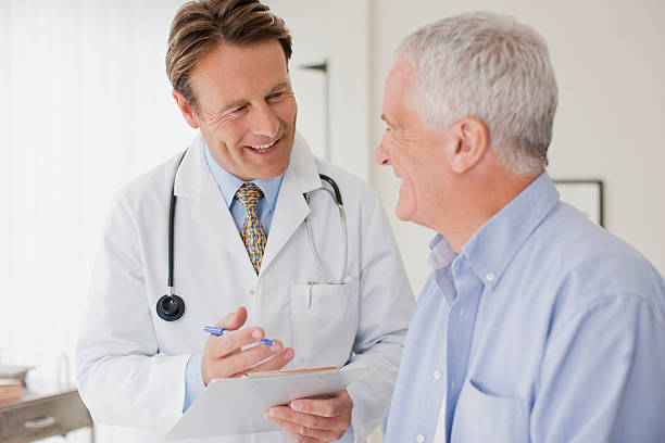 Doctor talking with patient in doctors office  doctor patient stock pictures, royalty-free photos & images