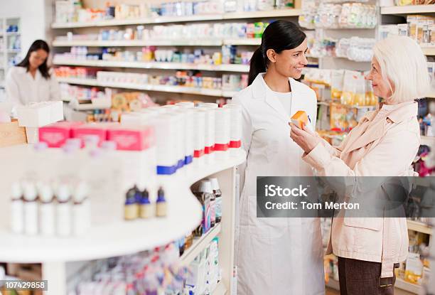 Pharmacist Talking To Customer In Drug Store Stock Photo - Download Image Now - Pharmacist, Medicine, Pharmacy