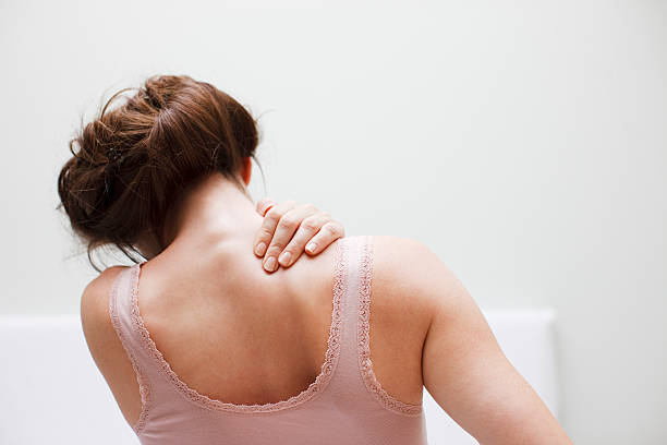 frau reiben rückenschmerzen - back rear view pain backache stock-fotos und bilder