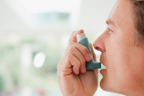 Hombre sobre el uso de inhalador de asma photo