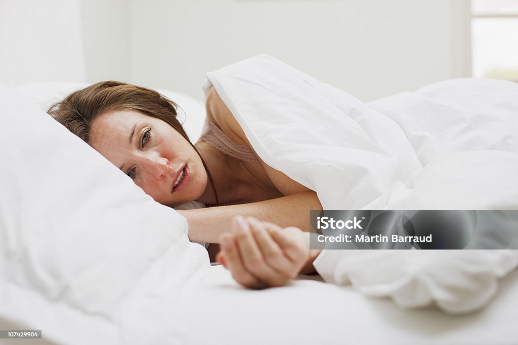 Male donna sdraiati a letto sotto coperta - Foto stock royalty-free di Donne