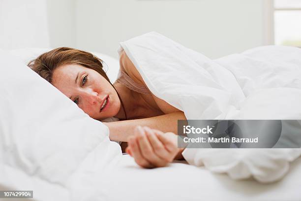 Sick Woman Laying In Bed Under Blanket Stock Photo - Download Image Now - Illness, Women, One Woman Only