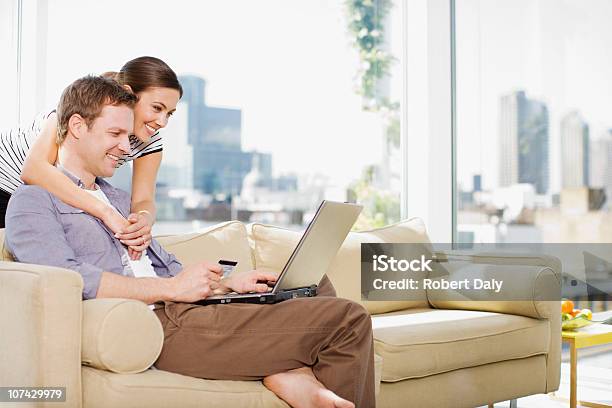 Couple Using Credit Card To Purchase Merchandise On Internet Stock Photo - Download Image Now