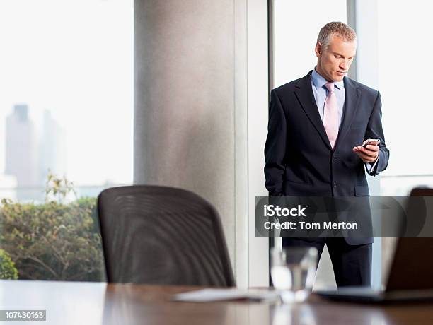 Empresário Mensagens De Texto No Telefone Celular No Escritório - Fotografias de stock e mais imagens de Diretor Executivo de Empresa