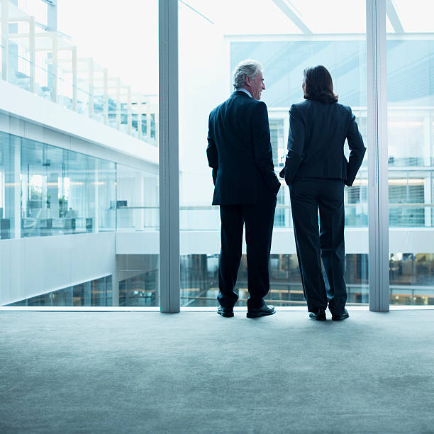 business persone che parlano vicino a parete in vetro in ufficio - looking through window window business women foto e immagini stock