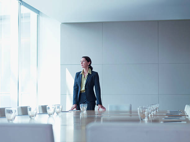 Businesswoman standing alone in conference room  chief executive officer stock pictures, royalty-free photos & images
