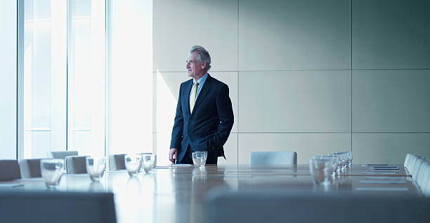 uomo d'affari in piedi da solo in sala conferenze - ceo foto e immagini stock