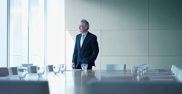 Photo of Businessman standing alone in conference room