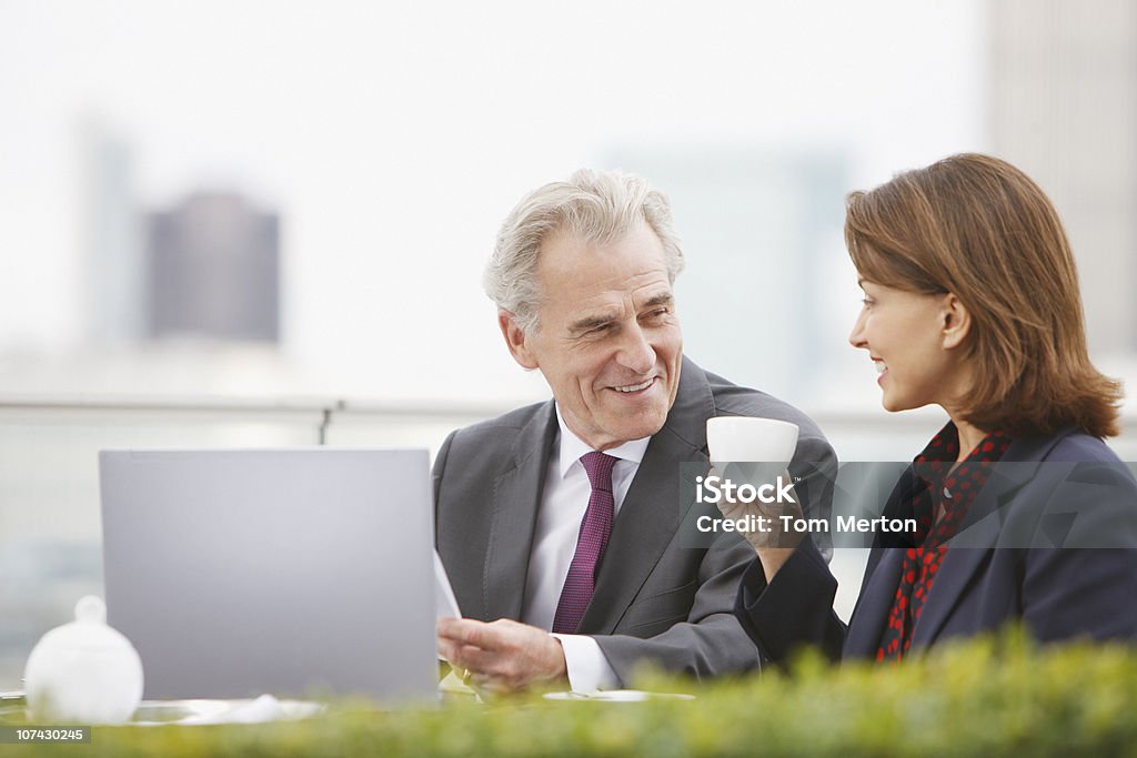 Uomini d'affari di bere caffè e lavorando all'aperto - Foto stock royalty-free di Ambientazione esterna