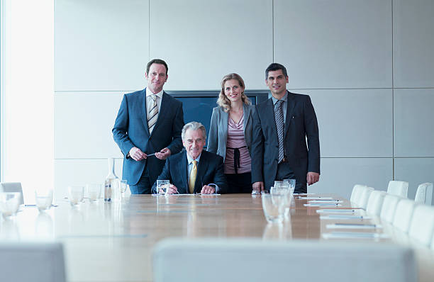 деловые люди, стоя вместе в конференц-зале - suit board room business businesswoman стоковые фото и изображения