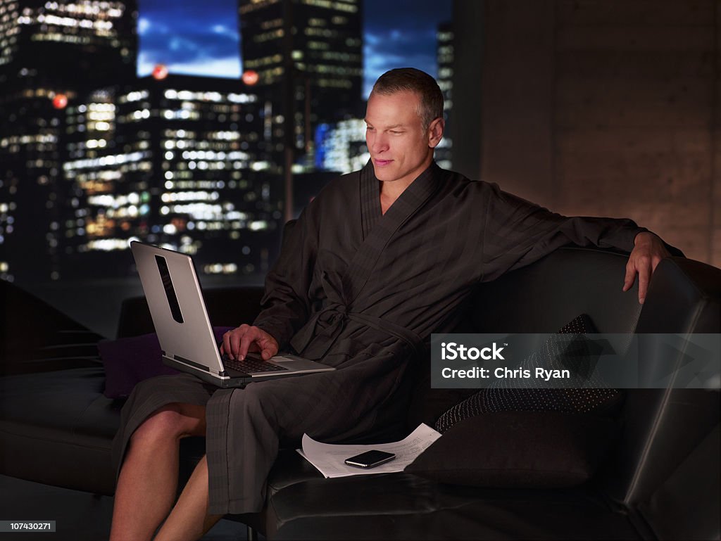 Homem com Roupão de Banho a trabalhar no computador portátil à noite - Royalty-free 40-44 anos Foto de stock