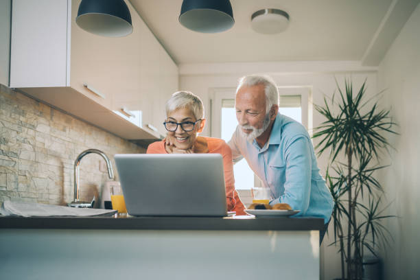 istock Cheerful senior couple looking at social media while having breakfast 1074315578