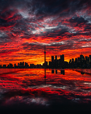Amazing sunset scene of Toronto cityscape with dramatic colors and reflection of city below. Rare sky with intense, gorgeous colors and clouds. Toronto, Ontario, Canada
