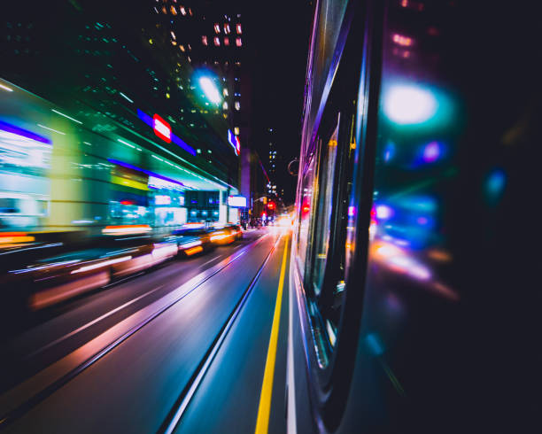 TORONTO STREETCAR SPEEDING THROUGH DOWNTOWN CITY AT NIGHT Fast-motion public transit vehicle speeding down street core with beautiful color streaks. Train transportation. Toronto, Ontario, Canada blurred motion street car green stock pictures, royalty-free photos & images
