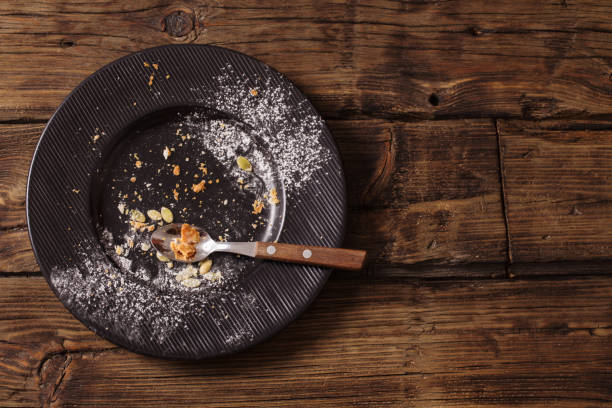 istock empty dirty plate on old wooden background 1074348786